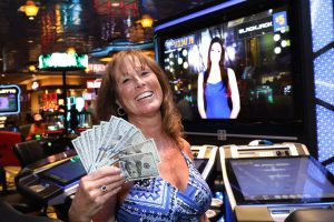 Woman holding cash in casino electronic table games