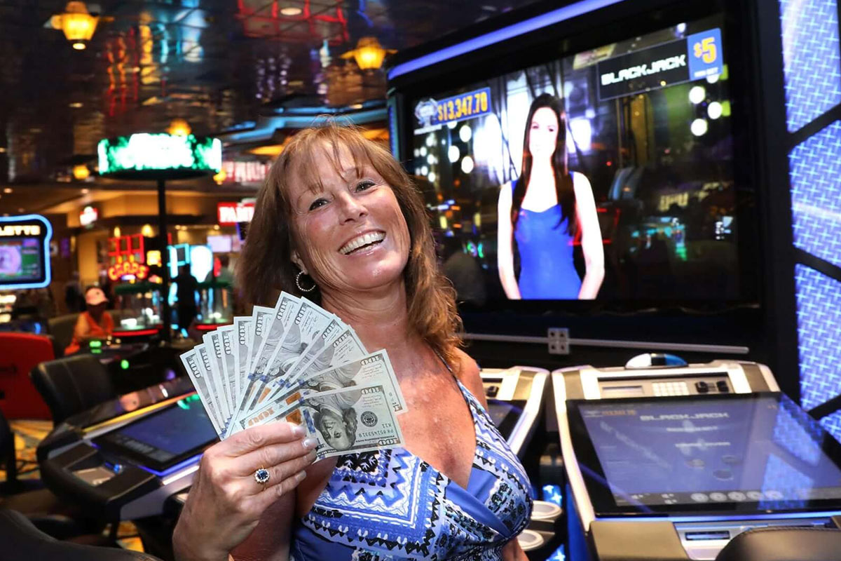 Woman holding cash in casino electronic table games