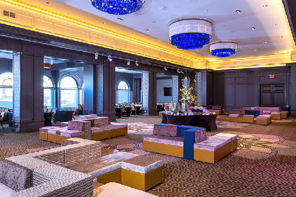 Spacious event lounge with modern seating, large chandeliers, and soft lighting. Conferences meetings events in AC.